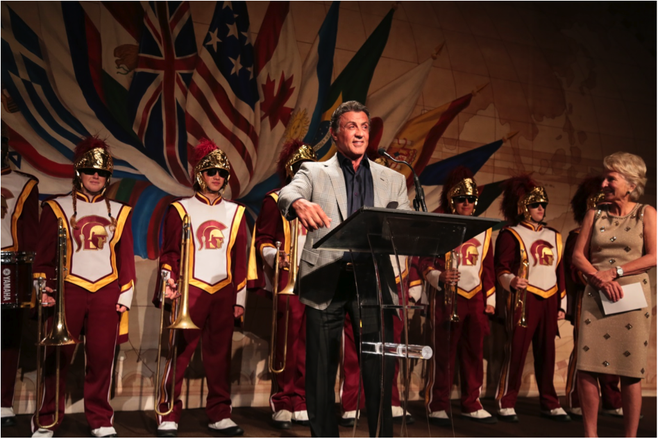 Sylvester Stallone appears on stage at the Woodrow Wilson Awards with the USC marching band and Wilson Center CEO, President & former U.S. Representative Jane Harman to introduce award recipient Robert Rodriguez at the Beverly Wilshire Hotel in Beverly Hills, CA